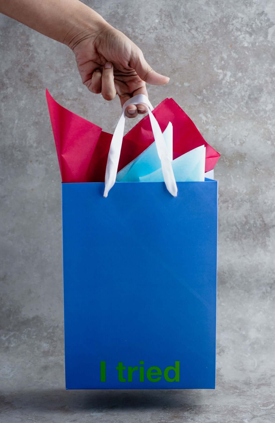 Funny gift bag in blue holding colorful tissue paper, with the phrase 'I tried' prominently displayed.