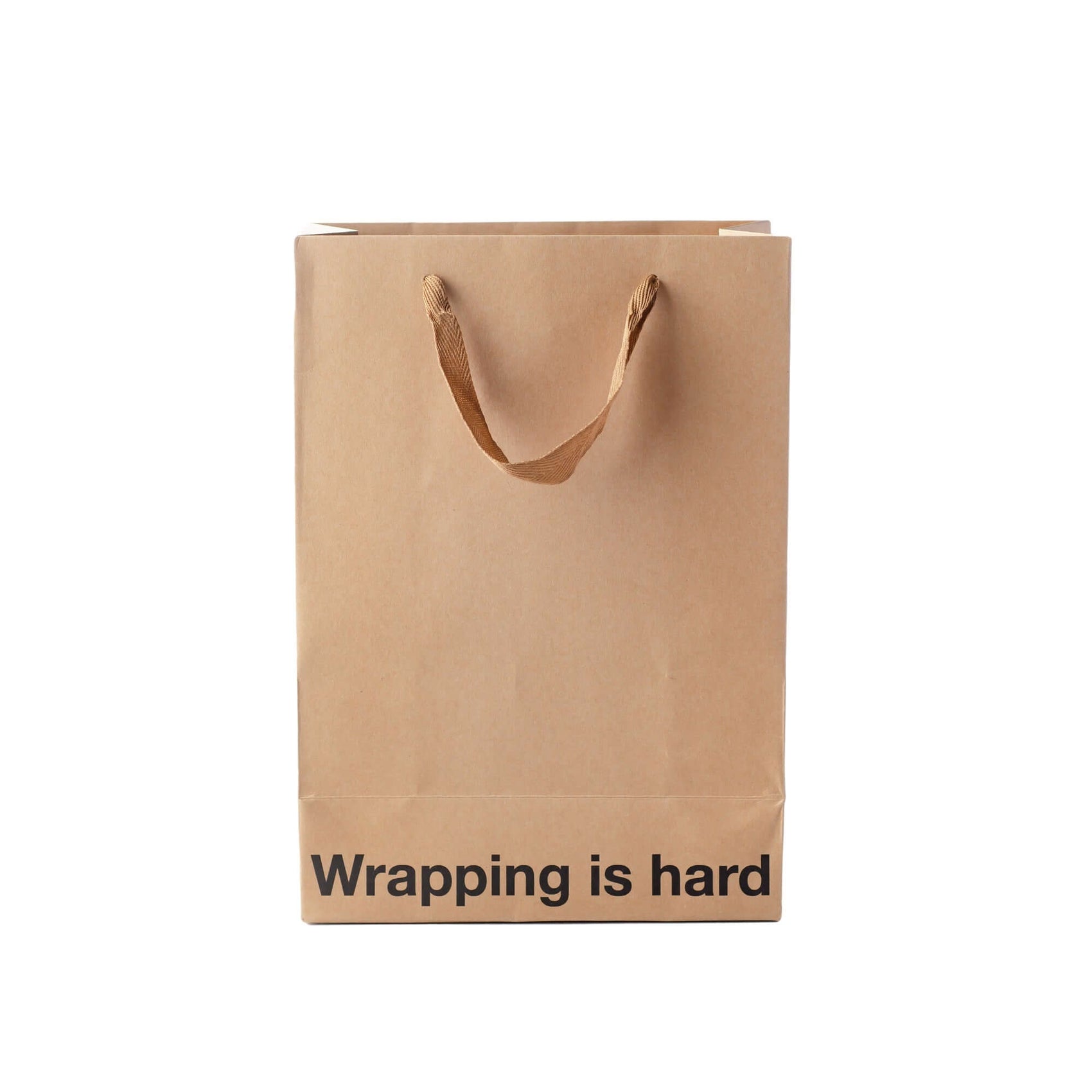 Funny gift bag with brown ribbon handles and "Wrapping is hard" printed on kraft paper.