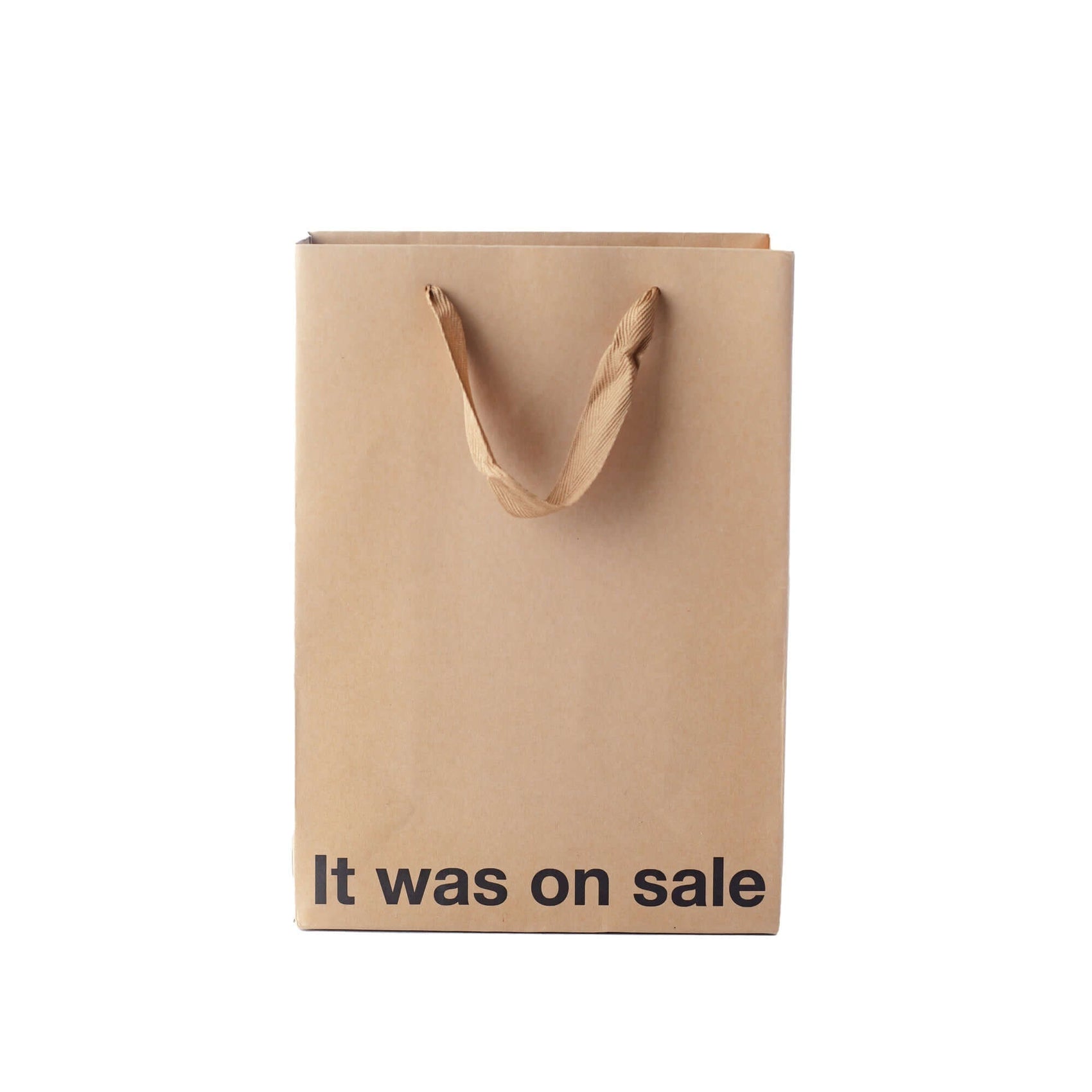 Funny gift bag made of kraft material with brown ribbon handle and text that says 'It was on sale'.