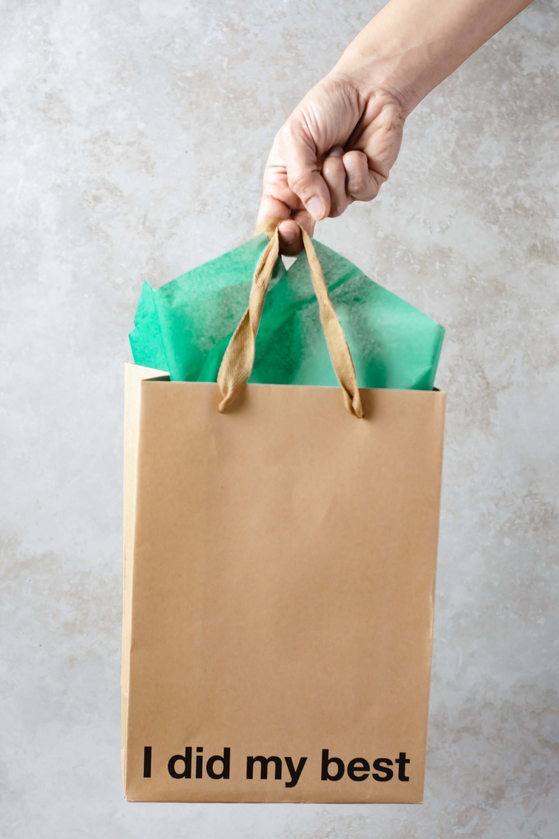 Funny gift bags featuring a kraft bag that says 'I did my best' held by a hand.