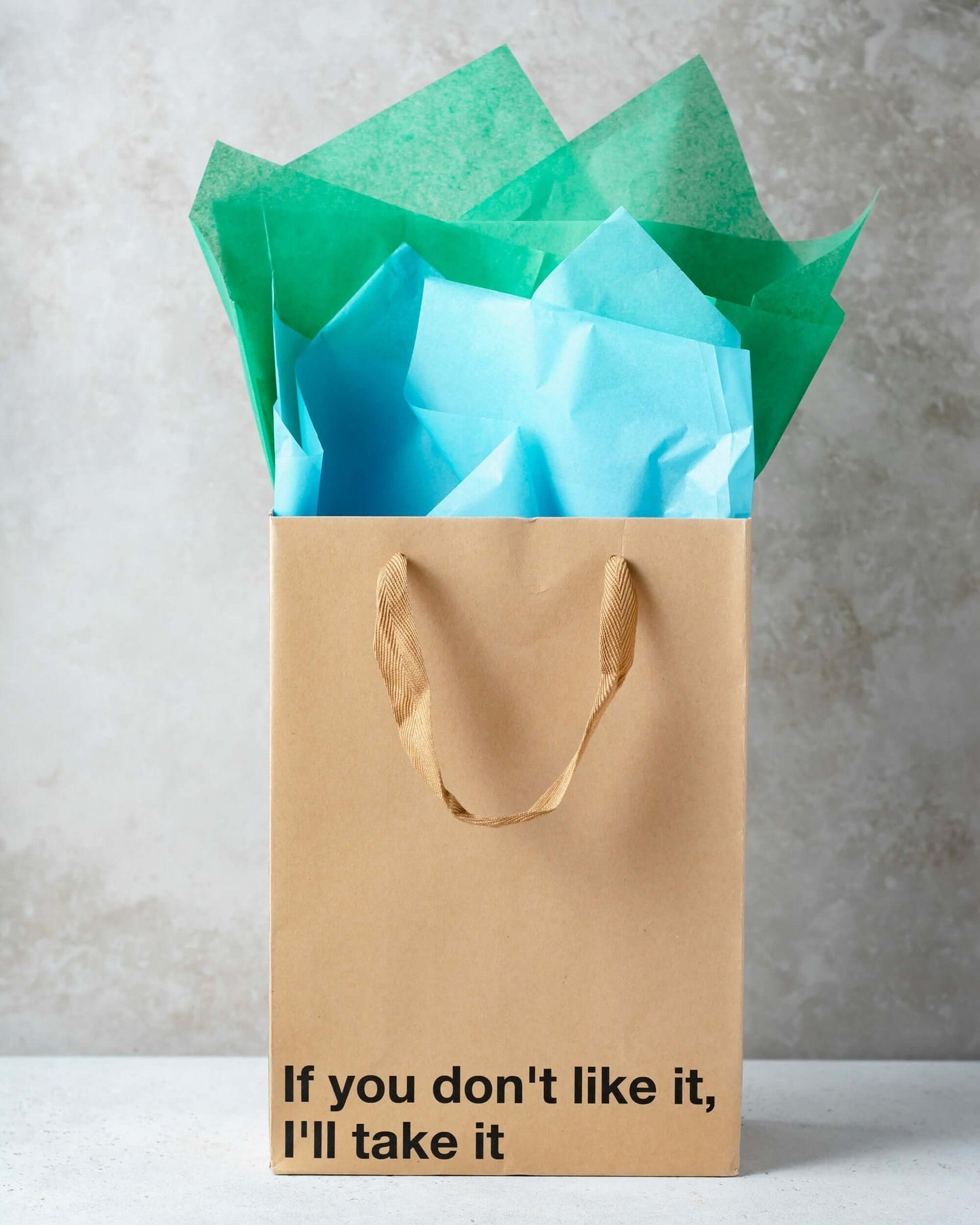 Funny gift bag with the phrase 'If you don't like it, I'll take it' and colorful tissue paper.