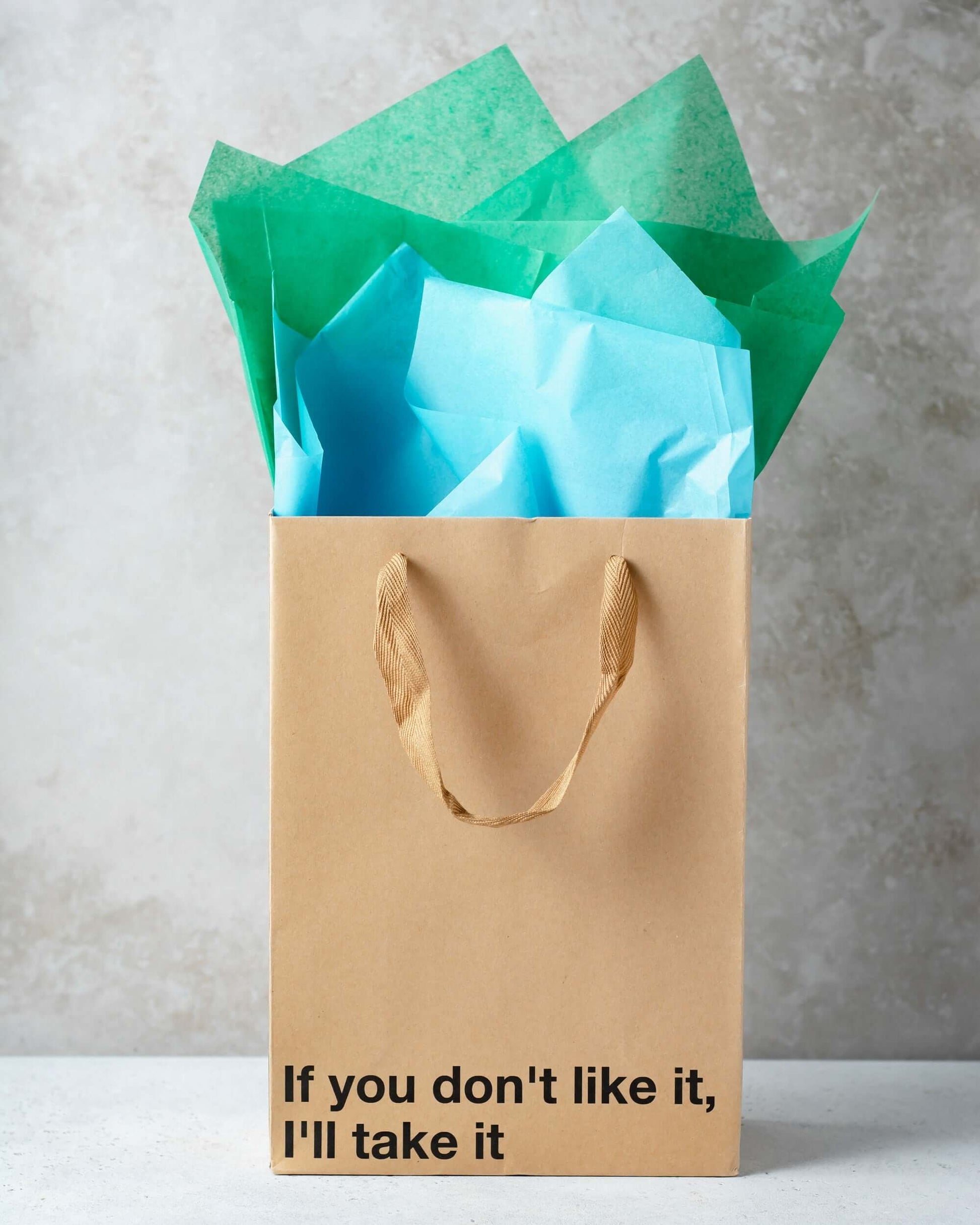 Funny gift bag with the phrase 'If you don't like it, I'll take it' and colorful tissue paper.
