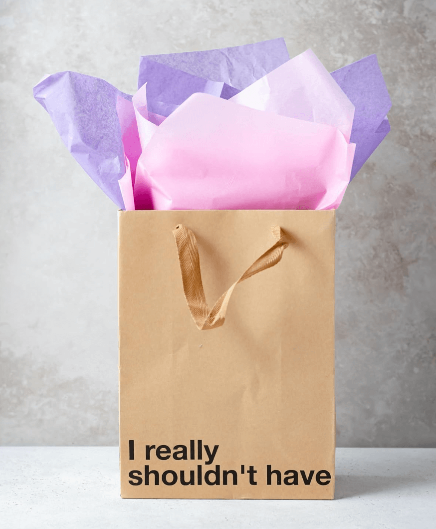 Funny gift bags featuring a kraft bag with the phrase 'I really shouldn't have' and colorful tissue paper.