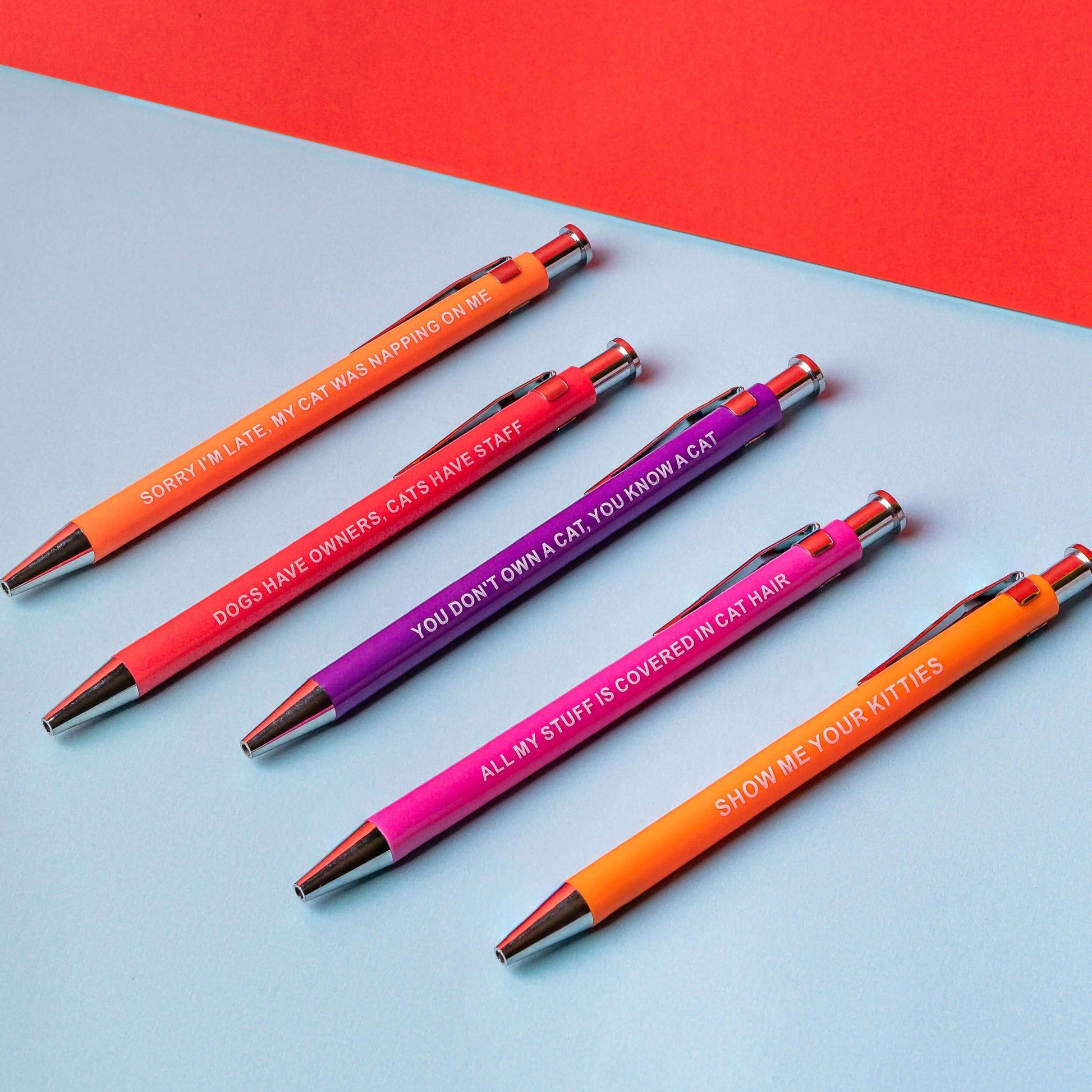 Sarcastic pens with colorful cat-themed designs and humorous sayings.