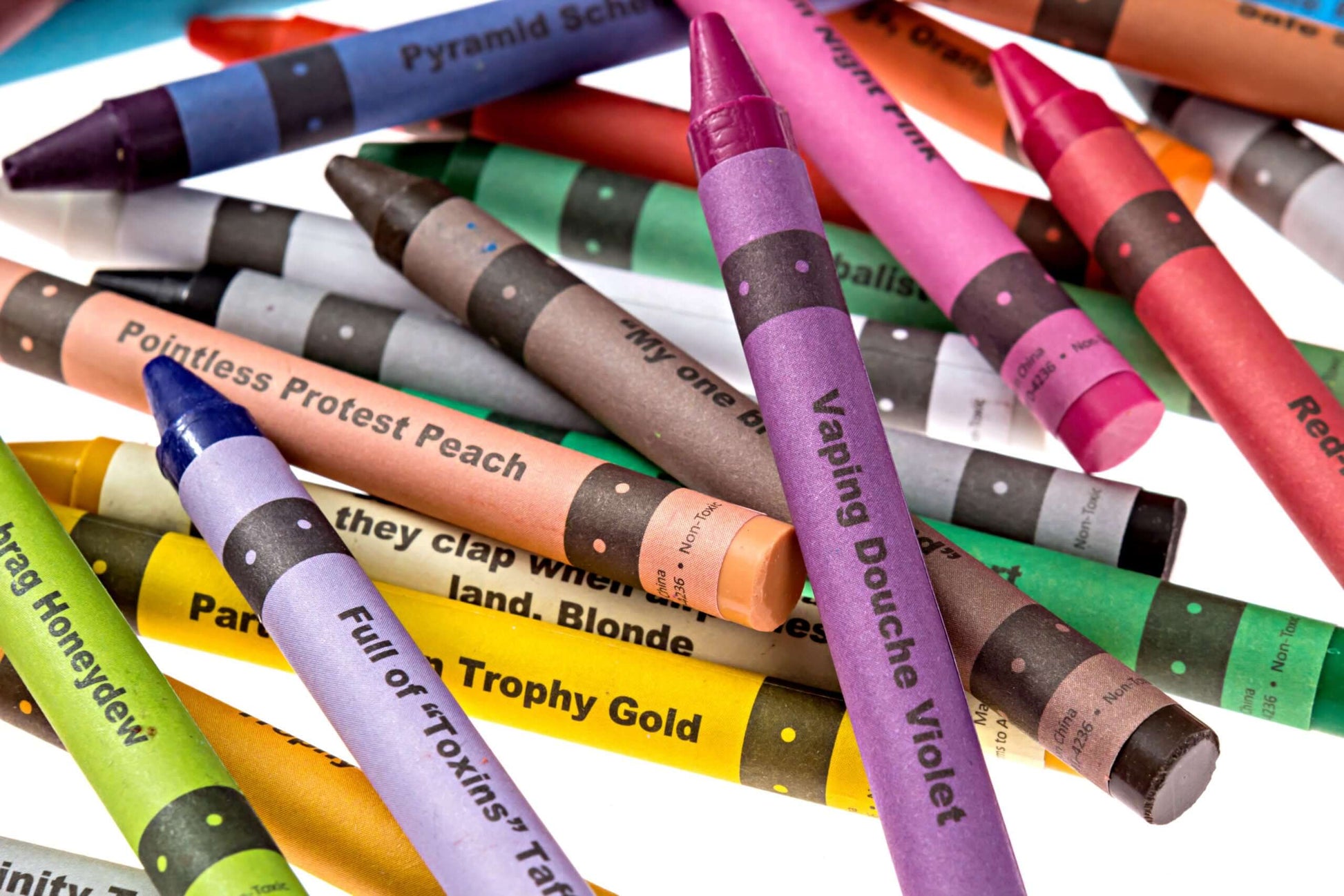 A colorful assortment of Offensive Crayons, featuring humorous names like Vaping Douche Violet and Pointless Protest Peach.