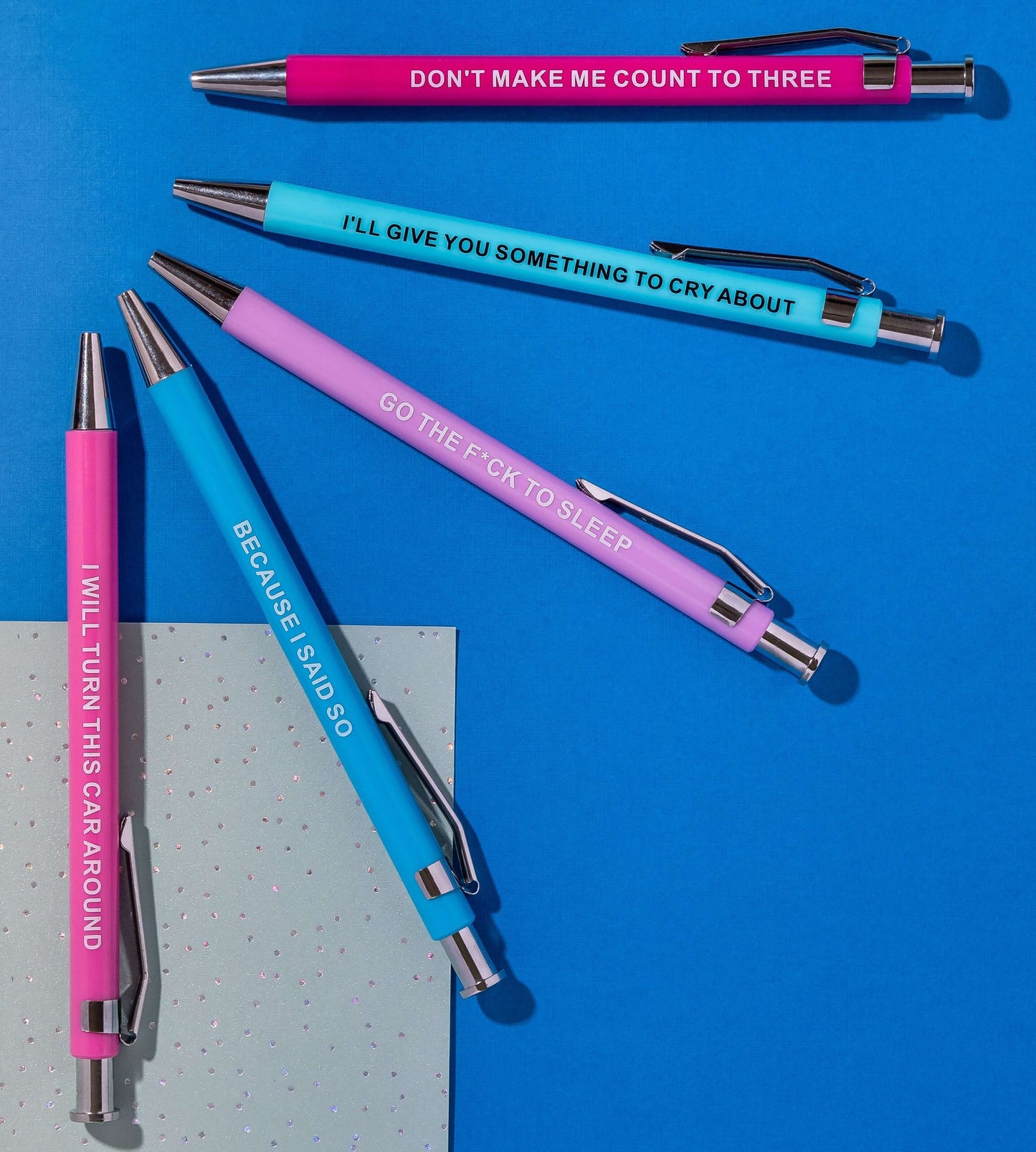 Colorful funny pens with humorous phrases like 'I’ll give you something to cry about' and 'Go the f*ck to sleep.'