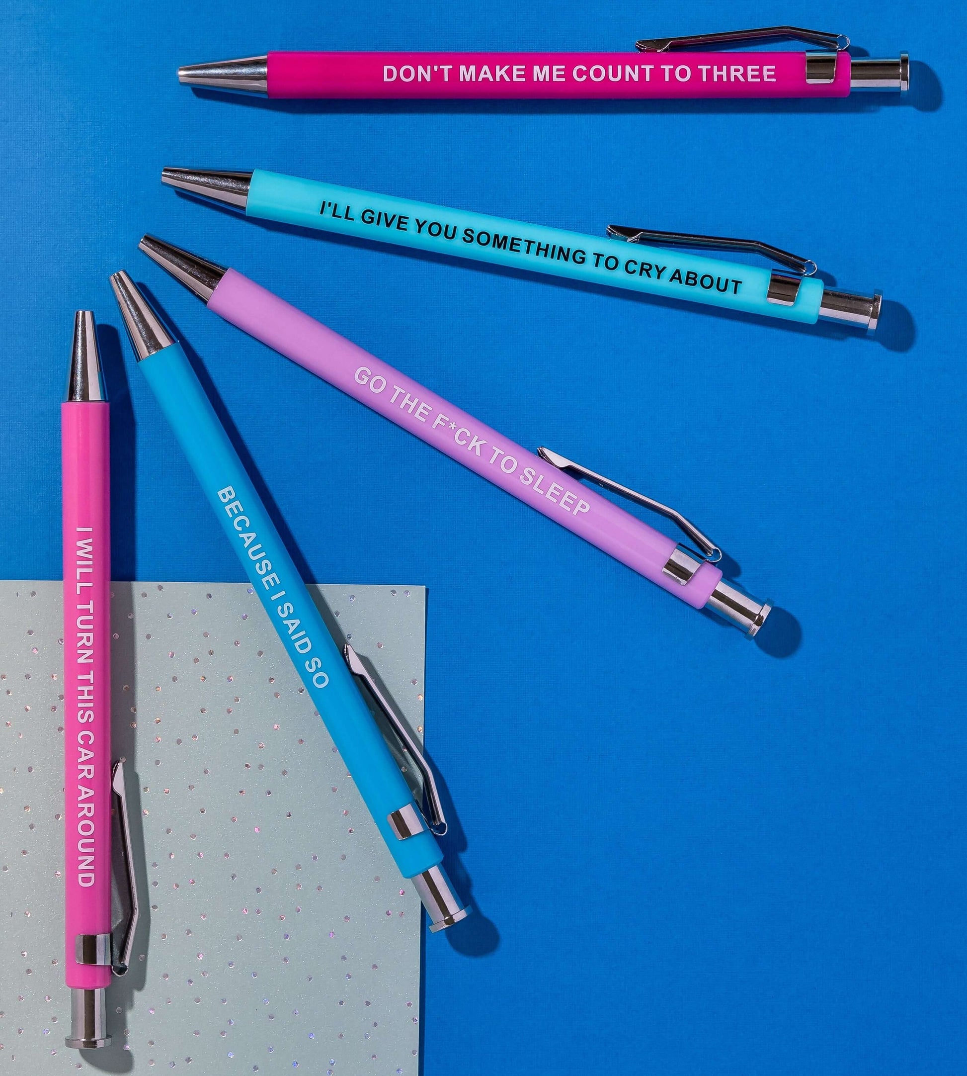 Colorful funny pens with humorous phrases like 'I’ll give you something to cry about' and 'Go the f*ck to sleep.'
